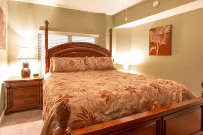 a bedroom with a large bed with a wooden frame at Shores of Panama #1502 by Book That Condo in Panama City Beach