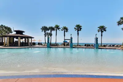 a large swimming pool with palm trees and a gazebo at Shores of Panama #1627 by Book That Condo in Panama City Beach