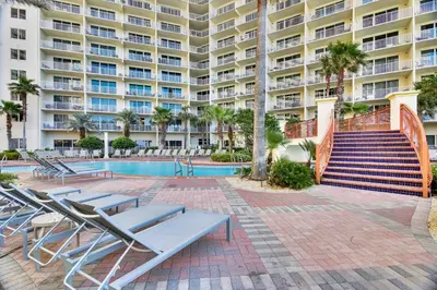 a swimming pool with lounge chairs and a building at Shores of Panama #1627 by Book That Condo in Panama City Beach