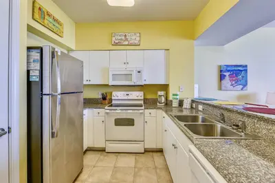 a kitchen with a stainless steel refrigerator and a sink at Shores of Panama #1714 by Book That Condo in Panama City Beach