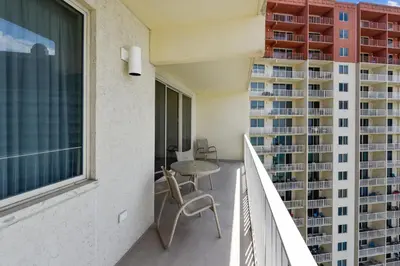 a balcony with a table and chairs and a building at Shores of Panama #1714 by Book That Condo in Panama City Beach