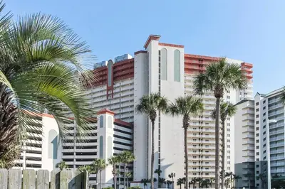 a tall white building with palm trees in front of it at Shores of Panama #1714 by Book That Condo in Panama City Beach