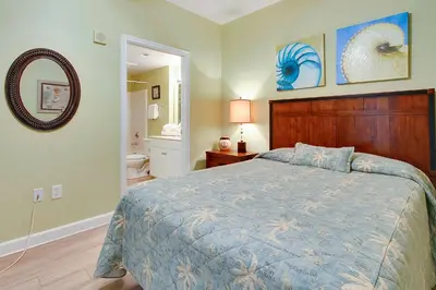 a bedroom with a bed and a mirror and a bathroom at Shores of Panama #2020 by Book That Condo in Panama City Beach