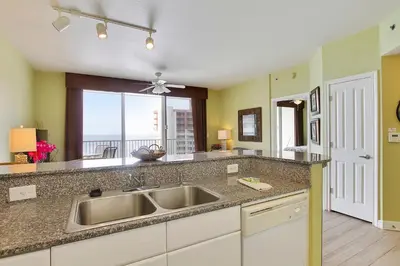 a kitchen with a sink and a large window at Shores of Panama #2020 by Book That Condo in Panama City Beach