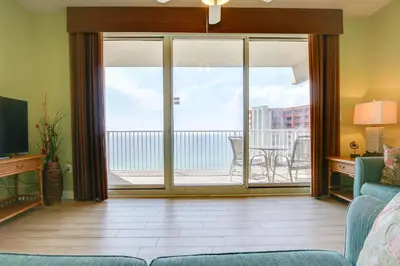 a living room with a couch and a sliding glass door at Shores of Panama #2020 by Book That Condo in Panama City Beach