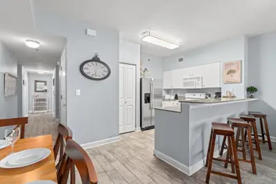 a kitchen and dining room with a clock on the wall at Shores of Panama #624 by Book That Condo in Panama City Beach