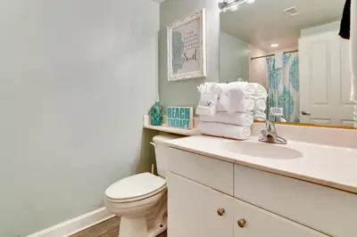 a bathroom with a toilet and a sink and a mirror at Shores of Panama #624 by Book That Condo in Panama City Beach