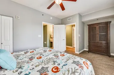 a bedroom with a bed and a ceiling fan at Shores of Panama #1007 by Book That Condo in Panama City Beach