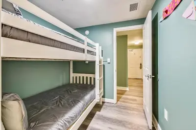 a bedroom with two bunk beds and a hallway at Shores of Panama #1007 by Book That Condo in Panama City Beach