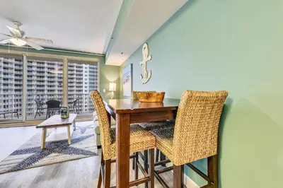 a dining room with a wooden table and chairs at Shores of Panama #1007 by Book That Condo in Panama City Beach