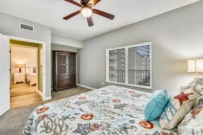 a bedroom with a bed and a ceiling fan at Shores of Panama #1007 by Book That Condo in Panama City Beach