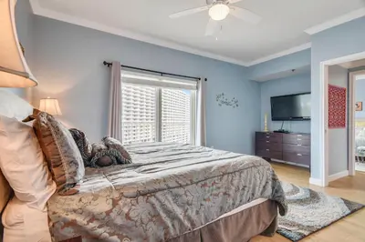 a bedroom with a large bed and a television at Shores of Panama #1119 by Book That Condo in Panama City Beach