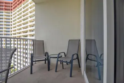 three chairs sitting on a balcony with buildings at Shores of Panama #1119 by Book That Condo in Panama City Beach