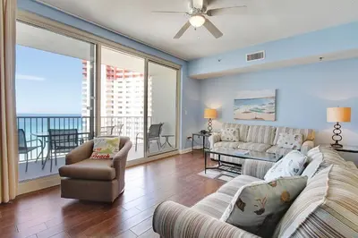 a living room with a couch and chairs and a balcony at Shores of Panama #1421 by Book That Condo in Panama City Beach