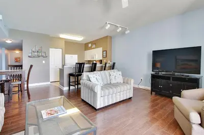 a living room with a couch and a tv at Shores of Panama #1421 by Book That Condo in Panama City Beach