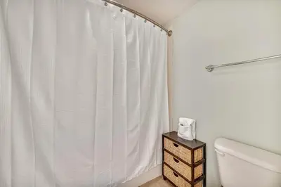 a bathroom with a white shower curtain and a toilet at Shores of Panama #1531 by Book That Condo in Panama City Beach