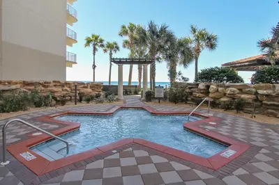 a swimming pool in front of a building with palm trees at Shores of Panama #1531 by Book That Condo in Panama City Beach