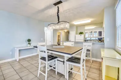 a dining room and kitchen with a table and chairs at Shores of Panama #1531 by Book That Condo in Panama City Beach