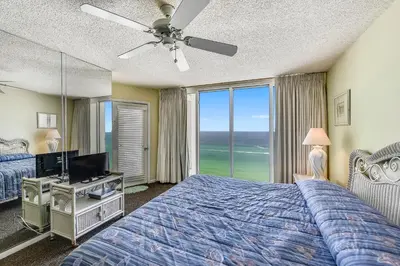 a bedroom with a bed and a ceiling fan at Long Beach Resort #1300-1 by Book That Condo in Panama City Beach