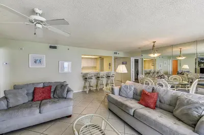 a living room with two couches and a kitchen at Long Beach Resort #1300-1 by Book That Condo in Panama City Beach