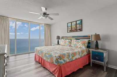 a bedroom with a bed with a view of the ocean at Long Beach Resort #1300-1 by Book That Condo in Panama City Beach