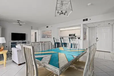 a dining room and kitchen with a table and chairs at Long Beach Resort #1300-1 by Book That Condo in Panama City Beach