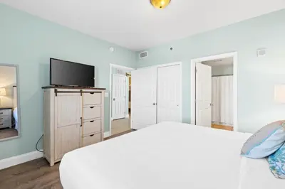 a bedroom with a white bed and a flat screen tv at Laketown Wharf Resort #1321 by Book That Condo in Panama City Beach