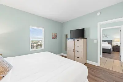a bedroom with a white bed and a television at Laketown Wharf Resort #1321 by Book That Condo in Panama City Beach