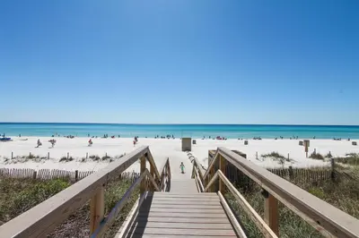 a wooden boardwalk to the beach with people on it at Majestic Beach Resort #1502-1 by Book That Condo in Panama City Beach