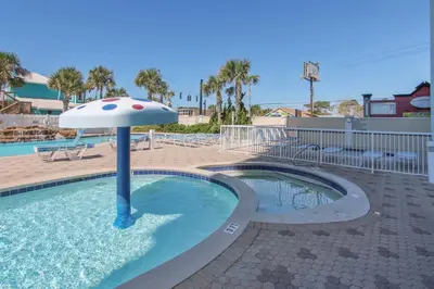 a swimming pool with an umbrella in the water at Majestic Beach Resort #1502-1 by Book That Condo in Panama City Beach