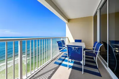a balcony with blue chairs and a table and the ocean at Majestic Beach Resort #1502-1 by Book That Condo in Panama City Beach