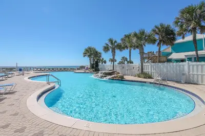 a swimming pool at a resort with palm trees at Majestic Beach Resort #1215-1 by Book That Condo in Panama City Beach