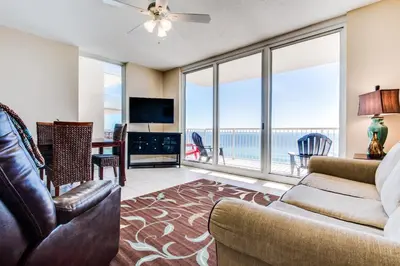 a living room with a couch and a table with a television at Majestic Beach Resort #1215-1 by Book That Condo in Panama City Beach