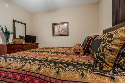 a bedroom with a bed and a dresser and a mirror at Majestic Beach Resort #1215-1 by Book That Condo in Panama City Beach