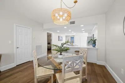 a dining room and kitchen with a glass table and chairs at Majestic Beach Resort #1309-2 by Book That Condo in Panama City Beach