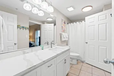a white bathroom with a sink and a mirror at Majestic Beach Resort #1307-1 by Book That Condo in Panama City Beach