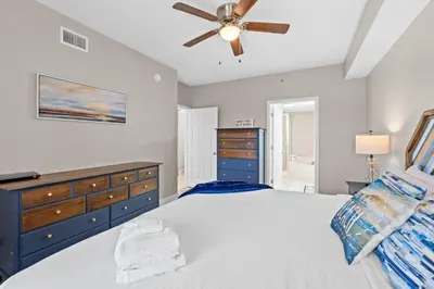 a bedroom with a bed and a ceiling fan at Majestic Beach Resort #1307-1 by Book That Condo in Panama City Beach