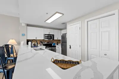 a white kitchen with a large white counter top at Majestic Beach Resort #1307-1 by Book That Condo in Panama City Beach