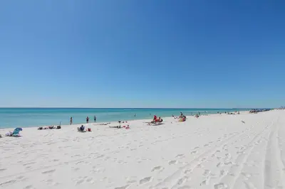 a group of people on a beach near the ocean at Majestic Beach Resort #1307-1 by Book That Condo in Panama City Beach