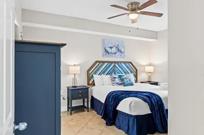 a bedroom with a bed and a ceiling fan at Majestic Beach Resort #1307-1 by Book That Condo in Panama City Beach