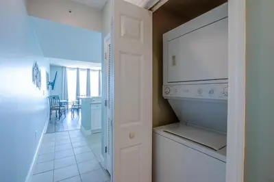 a kitchen with a refrigerator and a dining room at Majestic Beach Resort #1613-1 by Book That Condo in Panama City Beach