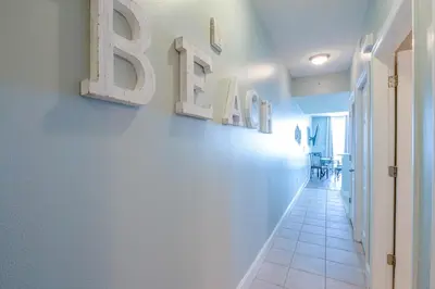 a hallway with a white wall with letters on it at Majestic Beach Resort #1613-1 by Book That Condo in Panama City Beach
