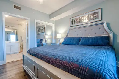 a bedroom with a bed with a blue comforter at Majestic Beach Resort #1613-1 by Book That Condo in Panama City Beach