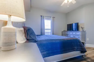 a bedroom with a bed and a table with a lamp at Majestic Beach Resort #1613-1 by Book That Condo in Panama City Beach