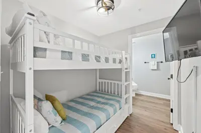 a white bunk bed in a white room at Tidewater Beach Resort #614 by Book That Condo in Panama City Beach