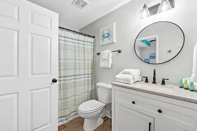 a bathroom with a toilet and a sink and a mirror at Tidewater Beach Resort #614 by Book That Condo in Panama City Beach