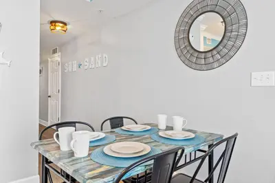 a dining room table with chairs and a mirror at Tidewater Beach Resort #614 by Book That Condo in Panama City Beach