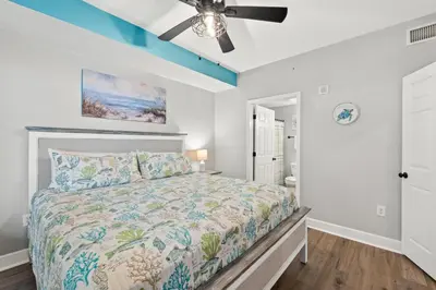 a bedroom with a bed and a ceiling fan at Tidewater Beach Resort #614 by Book That Condo in Panama City Beach
