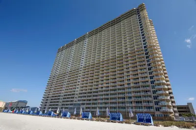 a large building on the beach with blue beach chairs at Tidewater Beach Resort #614 by Book That Condo in Panama City Beach