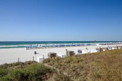 a beach with chairs and the ocean in the background at Tidewater Beach Resort #614 by Book That Condo in Panama City Beach